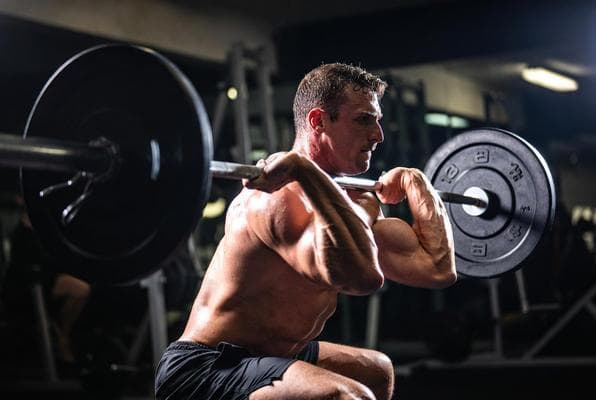 Personal trainer doing barbell squat